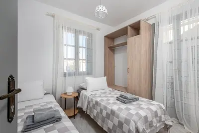 a bedroom with two beds and a window at FOURLANOU HOUSE in Halki