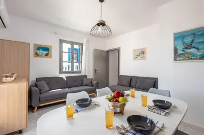 a living room with a white table and a couch at FOURLANOU HOUSE in Halki