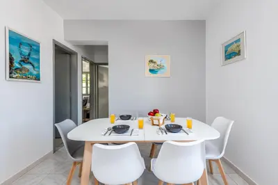 a white dining room with a white table and chairs at FOURLANOU HOUSE in Halki