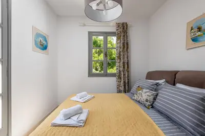 a bedroom with a bed and a window at FOURLANOU HOUSE in Halki
