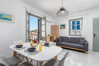 a living room with a white table and chairs at FOURLANOU HOUSE in Halki