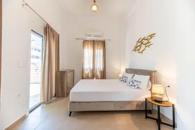 a white bedroom with a bed and a window at Kira's House Rhodes Town in Rhodes Town