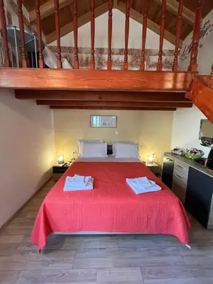 a bedroom with a bed with a red bedspread at Foteini’s House in Symi