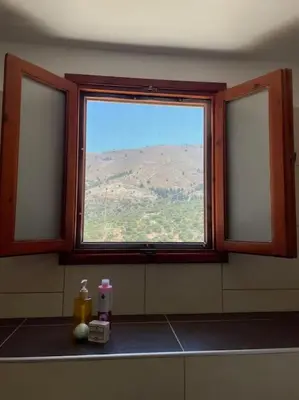 a window in a bathroom with a view of a mountain at Foteini’s House in Symi