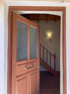 a wooden door in a room with a staircase at Foteini’s House in Symi