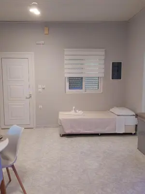 a bedroom with a bed and a window and a chair at Sunny house in Kremasti