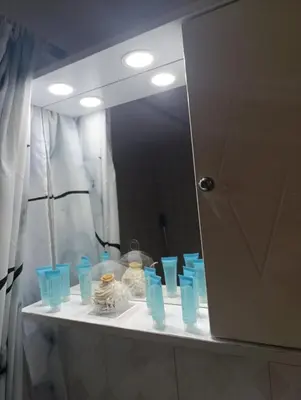 a bathroom mirror with blue cups on a counter at Sunny house in Kremasti