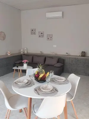 a white table with a bowl of fruit on it at Sunny house in Kremasti