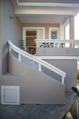 a house with a white railing and stairs at Mary's Luxury Residence in Koskinou