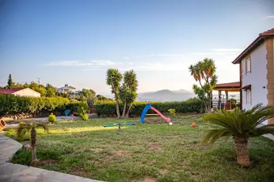 a yard with a playground with palm trees and a house at Mary's Luxury Residence in Koskinou