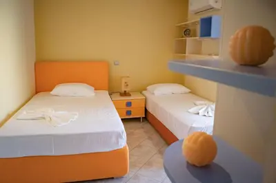 two beds in a room with two orange beds at Mary's Luxury Residence in Koskinou
