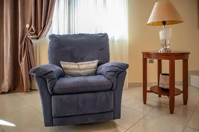 a blue chair sitting next to a table with a lamp at Mary's Luxury Residence in Koskinou