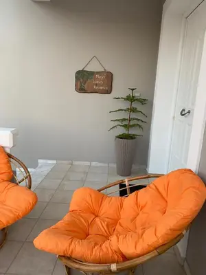 an orange chair in a room with a plant at Mary's Luxury Residence in Koskinou