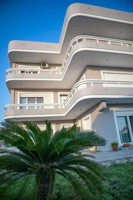 a building with a palm tree in front of it at Mary's Luxury Residence in Koskinou
