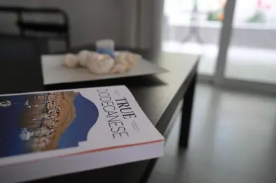 a book sitting on top of a table with donuts at Rhodes Retreat: Modern Comfort in Serene Luxury in Rhodes Town