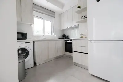 a white kitchen with a washer and dryer in it at Rhodes Retreat: Modern Comfort in Serene Luxury in Rhodes Town