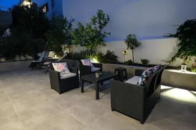 a patio with couches and tables on a rooftop at Rhodes Retreat: Modern Comfort in Serene Luxury in Rhodes Town