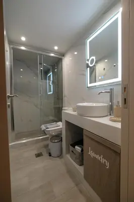 a bathroom with a sink and a toilet and a mirror at Rhodes Retreat: Modern Comfort in Serene Luxury in Rhodes Town