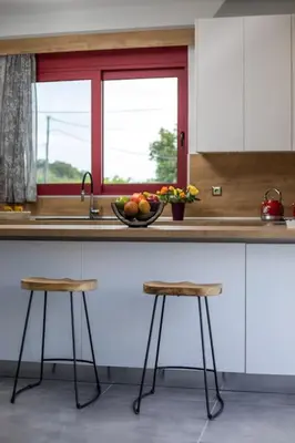 a kitchen counter with two stools and a bowl of fruit at SunDaLucky in Afantou