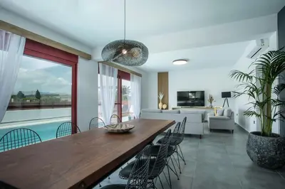 a dining room with a wooden table and chairs at SunDaLucky in Afantou