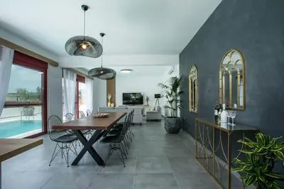 a dining room and living room with a table and chairs at SunDaLucky in Afantou