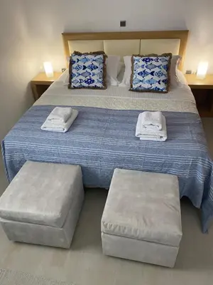 a bedroom with a large bed with two ottomans at Sunny Garden Villa Koskinou in Koskinou