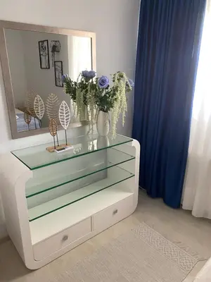 a dresser with a mirror and a vase with flowers on it at Sunny Garden Villa Koskinou in Koskinou