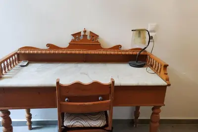 a wooden desk with a lamp and a chair at Heliophilia Malona in Malona Village