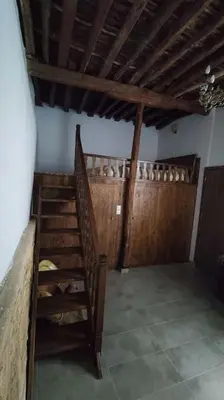 a room with a wooden staircase in a house at Heliophilia Malona in Malona Village