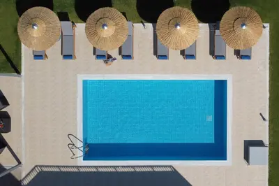 an overhead view of a swimming pool with umbrellas at Villa Arco Bianco in Afantou