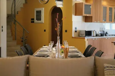 a dining room table with chairs and a tableclotholitics at Villa Arco Bianco in Afantou