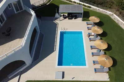 an overhead view of a swimming pool with umbrellas at Villa Arco Bianco in Afantou