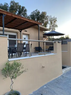 a balcony with a table and chairs and an umbrella at Thalia's House in Pastida