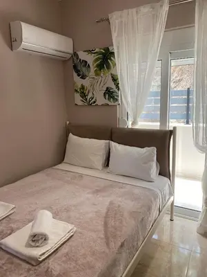 a bedroom with a bed with a fan and a window at Thalia's House in Pastida