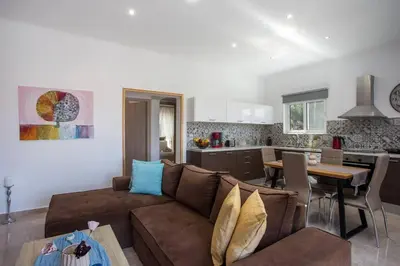 a living room with a couch and a table and a kitchen at Thalia's House in Pastida