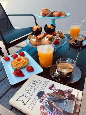a book on a table with breakfast foods and orange juice at Thalia's House in Pastida