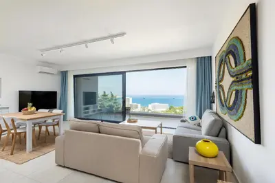 a living room with a couch and a table at Aquarama Pool Apt. - Blue in Ixia