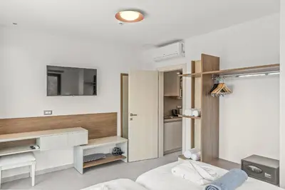 a bedroom with a bed and a tv on a wall at KOUROS STONE SUITES in Haraki