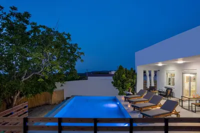 a swimming pool with lounge chairs and a house at Aelia Luxury Villa in Sálakos