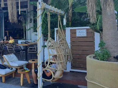 a person sitting in a swing in a restaurant at Anthias Beach Home in Archangelos