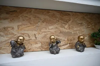 three bronze statues sitting on a shelf in front of a wall at Anthias Beach Home in Archangelos