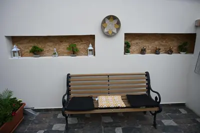 a bench sitting in a room with a clock on the wall at Anthias Beach Home in Archangelos