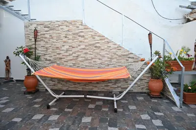 a hammock sitting on a patio with plants at Anthias Beach Home in Archangelos
