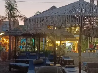 a group of tables and umbrellas in front of a building at Anthias Beach Home in Archangelos