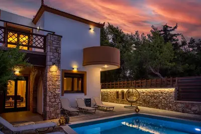 a house with a swimming pool in front of a house at Glamorous Villa Nefeli in Koskinou