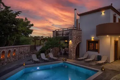 a house with a swimming pool with a sunset at Glamorous Villa Nefeli in Koskinou