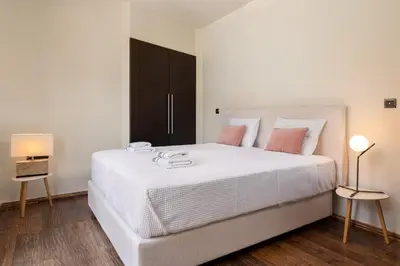 a bedroom with a large white bed with pink pillows at Glamorous Villa Nefeli in Koskinou