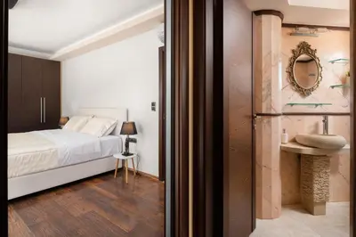 a bedroom with a bed and a bathroom with a sink at Glamorous Villa Nefeli in Koskinou