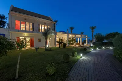 a large house with lights in a yard at night at Grande Dame Villa of Rhodes in Rhodes Town