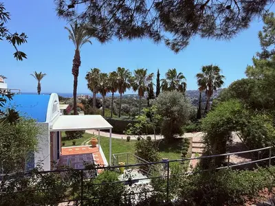 a house with a view of a yard with palm trees at Grande Dame Villa of Rhodes in Rhodes Town